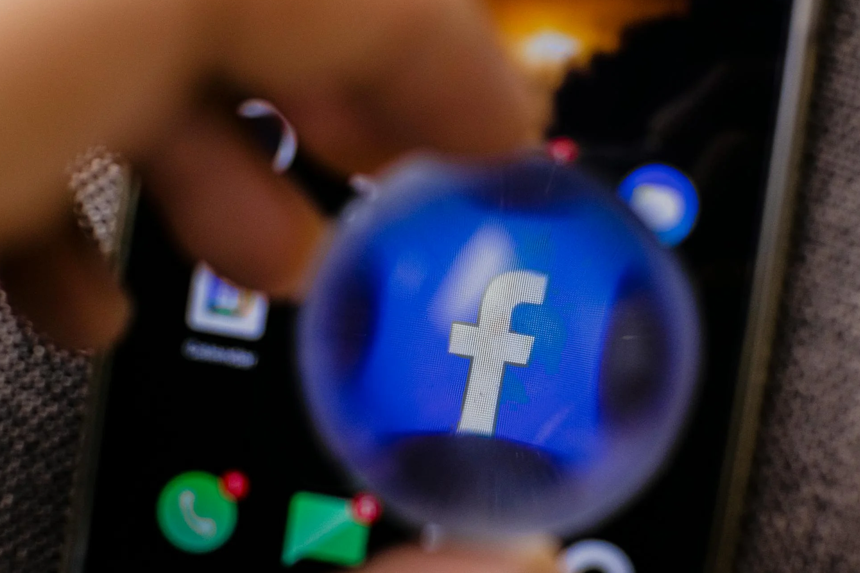 Facebook logo under magnifier