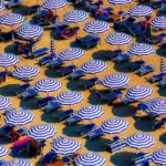 Rows of beach umbrellas and sun loungers offering shade during intense Tokyo summer heat