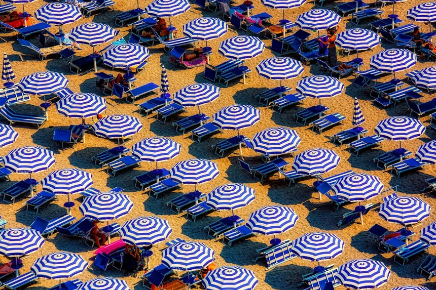 Rows of beach umbrellas and sun loungers offering shade during intense Tokyo summer heat