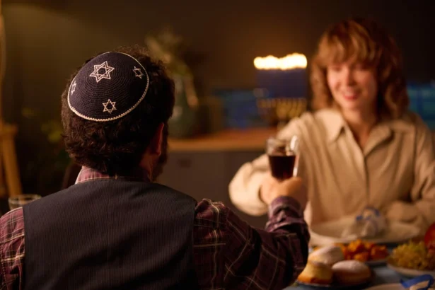 Man in yarmulke toasts woman during a festive Jewish celebration with food.